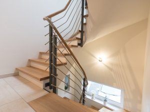 Betontreppe mit Eiche Stufen und Metallgeländer